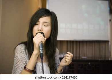 Young Woman Singing Karaoke, Eyes Closed