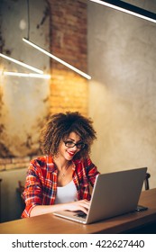 Young Woman Siting At Cafe Working On Laptop
