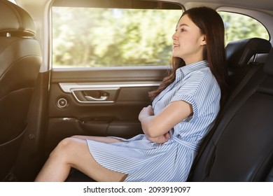 Young Woman Sitting At The Back Seat Of Car