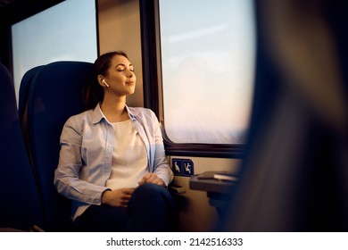 Young woman sitting by the window with her eyes closed while traveling by train. Copy space.  - Powered by Shutterstock