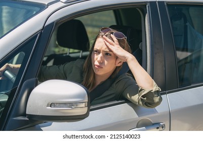 Young Woman Sitting In A Car Stuck In A Traffic Jam Feeling Stressed Because She Is Rushing To Work.