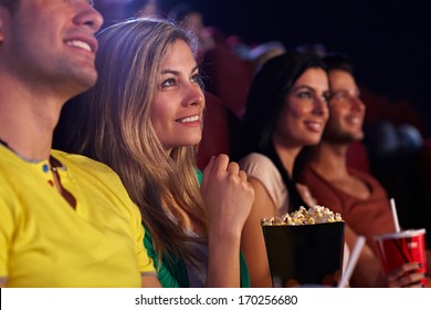 Young Woman Sitting In Cinema, Watching Movie, Smiling.