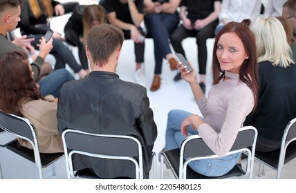 Young Woman Sitting In A Circle Of Her Like Minded