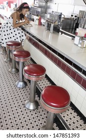 Young Woman Sitting At A Diner Counter