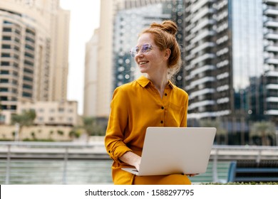 Young Woman Sitting In Dubai Marina Area And Work On Laptop. Student Or  Freelancer Lifestyle. 