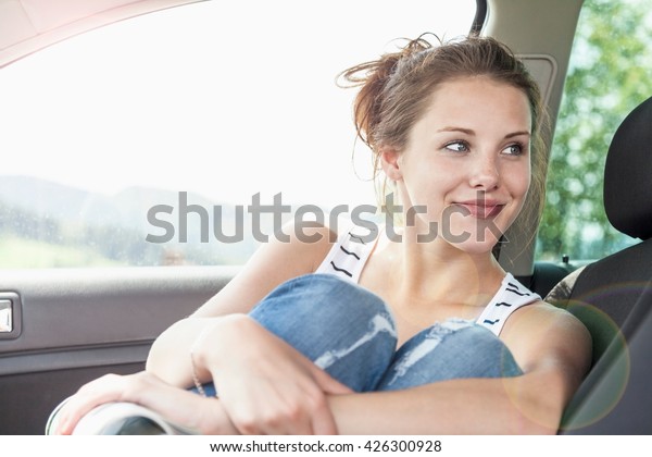 Young woman sitting in\
front seat of car