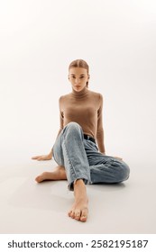 Young woman sitting gracefully on the floor in casual attire, exuding confidence in a modern studio setting