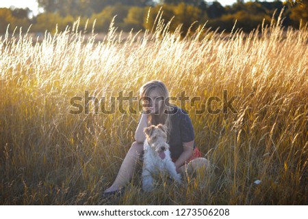 Young woman sitting in grass with her dog