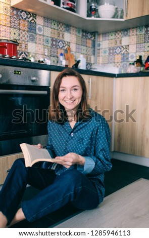 young woman sitting in the kitchen with a book
girl sitting on the kitchen floor