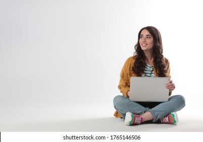 Young Woman Sitting With Laptop On White Background