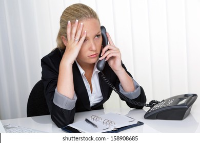 A Young Woman Sitting In Office And Calling Has Stress In