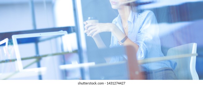 Young woman sitting at office table with laptop,view through window. Young woman - Shutterstock ID 1431274427