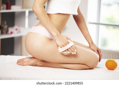 Young Woman Sitting On Bathroom Holding Handle Dry Brush To Side Of Her Thigh