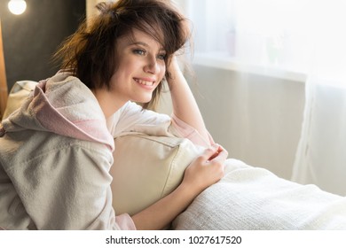 Young woman sitting on the couch at home in the morning - Shutterstock ID 1027617520