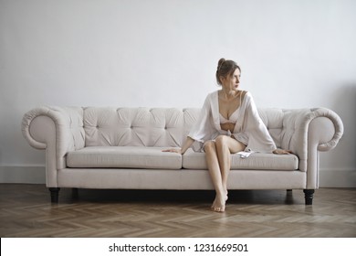 Young woman sitting on a couch. - Shutterstock ID 1231669501