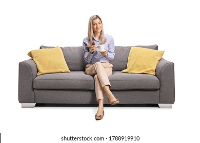 Young Woman Sitting On A Couch With A Cup Of Coffee Isolated On White Background