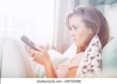 Young Woman Sitting On Couch At Home And Watching TV, Casual Style Indoor Shoot