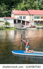 Young Woman Sitting On Paddle Board Wear Life Vest And Learn How Swim, Summer Active Lifestyle