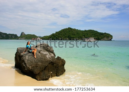 Young woman sitting on a rock at Wua Talab island, Ang Thong National Marine Park, Thailand