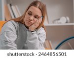 young woman sitting on the sofa at home with sad expression
