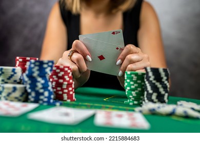 Young Woman Sitting On Table Playing Poker And Holding Cards Proudly Celebrating Victory And Success Very Excited. Poker Game Gambling Woman