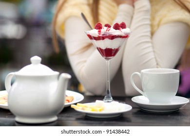 Young Woman Sitting In Outdoor Cafe Tasting Dessert