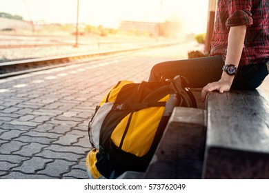 Young woman sitting in passenger station train with bag