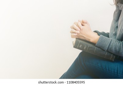 Young Woman Sitting And Prayer On Bible.copy Space