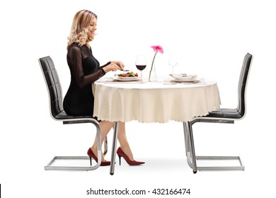 Young Woman Sitting At A Restaurant Table And Eating Dinner Alone Isolated On White Background