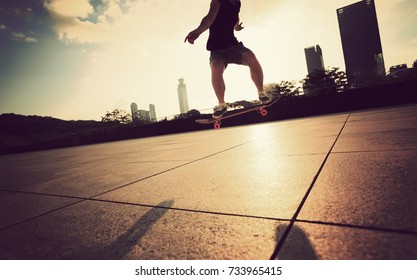 young woman skateboarder skateboarding at sunrise city - Shutterstock ID 733965415