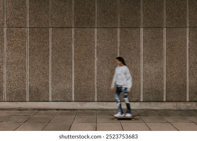 A young woman skateboarding, blurred motion, urban setting. The woman skateboarding wears street simple casual clothes. Skateboarding woman in an urban environment enjoying hobby, motion blur. - Powered by Shutterstock