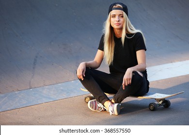 Young Woman With Skating Board On The Road