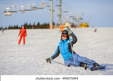 Young Woman Skier In Blue Ski Suit Trying Get Up After The Fall On Mountain Slope. Ski Resort. Winter Sports Concept. Ski Resort At Carpathian Mountains