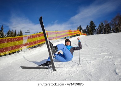 Young Woman Skier In Blue Ski Suit After The Fall On Mountain Slope. Ski Resort. Winter Sports Concept. Bukovel