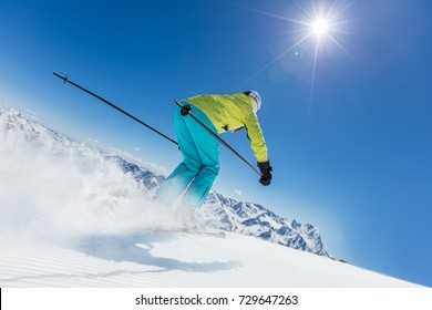 Young woman skier running down the slope in Alpine mountains. Winter sport and recreation, lesure outdoor activities.