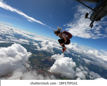 Young Woman Skydiver Jumping From The Plane Performing Front Loopings. Fearless And Confident. 