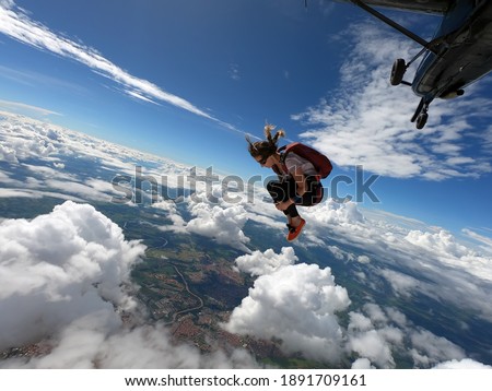 Young woman skydiver jumping from the plane performing front loopings. Fearless and confident.  Foto stock © 