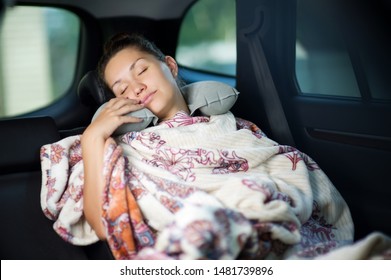 Young Woman Sleeping In The Backseat Of A Car