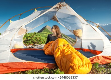 Young Woman in Sleeping Bag Watching Sunsete From Her Tent - Powered by Shutterstock