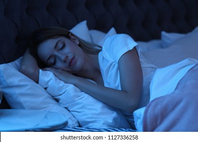 Young woman sleeping in bed at night. Sleeping time
