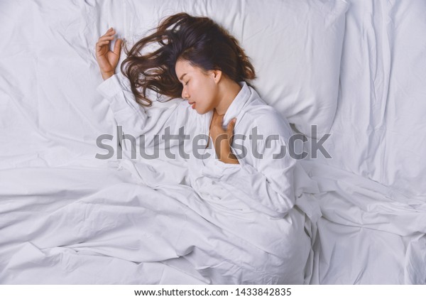 ベッドで眠る若い女性 ベッドの中でよく眠って横になっている若い女性の上からの眺め 寝てリラックスし 若く笑顔の美しい女性がベッドに横たわる の写真素材 今すぐ編集