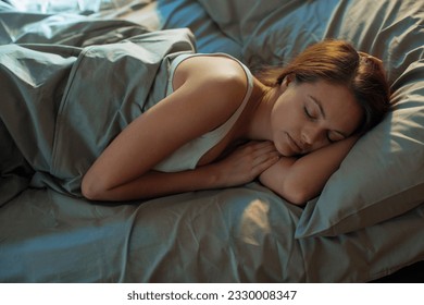 Young woman sleeping in her bed in the bedroom - Powered by Shutterstock