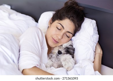 Young Woman  Sleeping With Her Dog In A Bed 