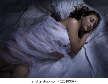 Young Woman Sleeping At Night In Bed