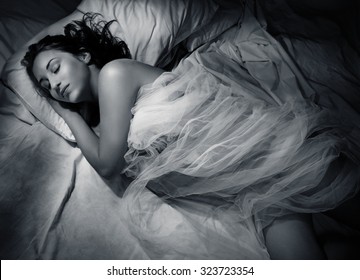 Young Woman Sleeping At Night In Bed