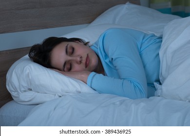 Young Woman Sleeping On Bed In Her Bedroom