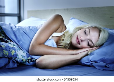 Young Woman Sleeping Peacefully At Night In Bed