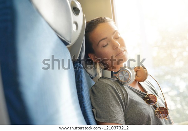 Young woman sleeping peacefully on train                
             