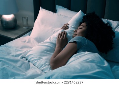 Young woman sleeping in soft bed at night - Powered by Shutterstock