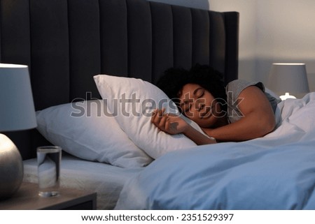 Young woman sleeping in soft bed at night